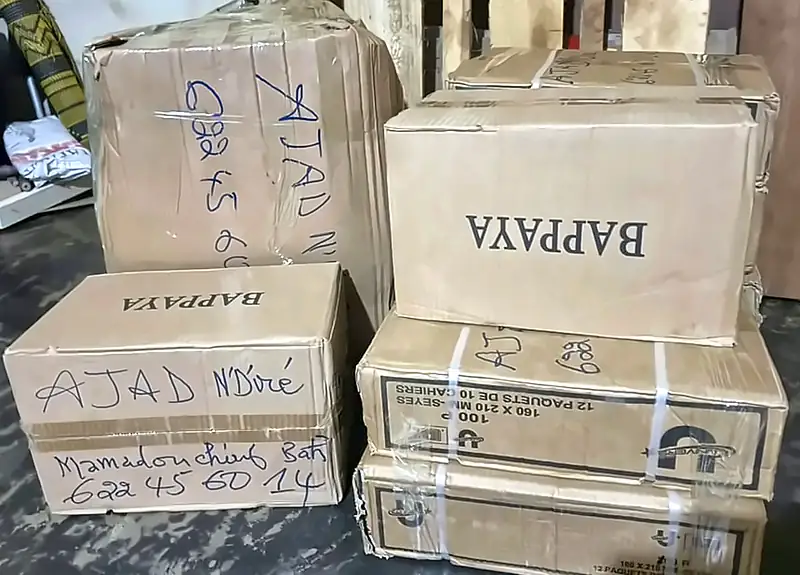 Cartons de fournitures scolaires marqués AJAD N'Diré, prêts à partir
